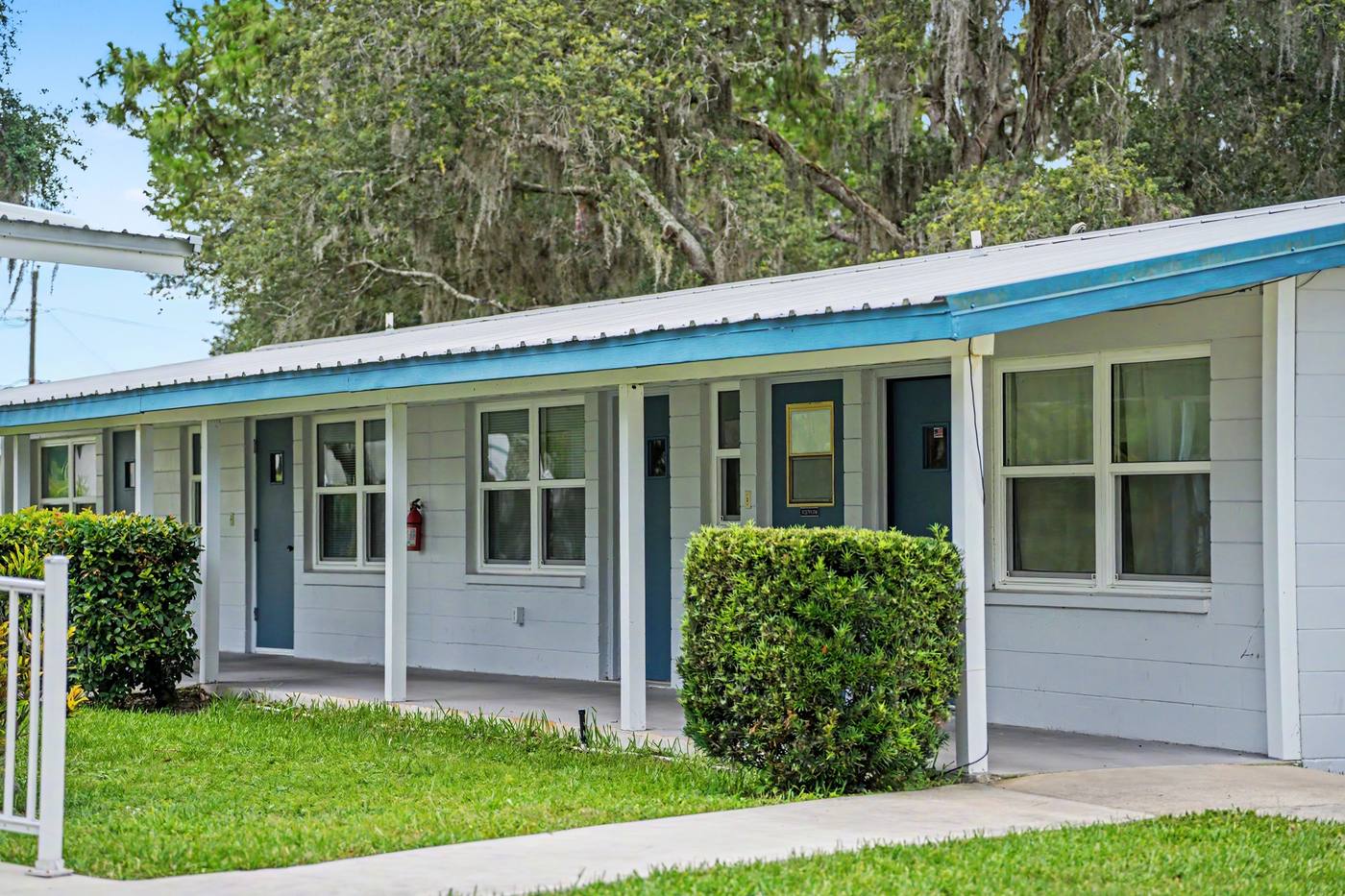 A row of apartments with a covered walkway and blue trim