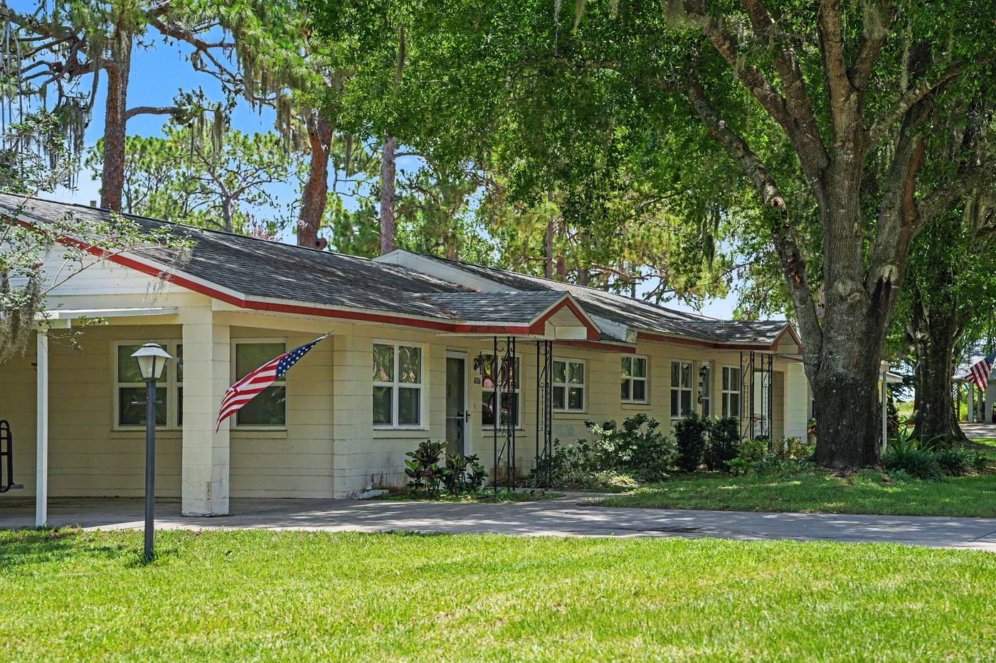 A duplex home with a lamppost and flag