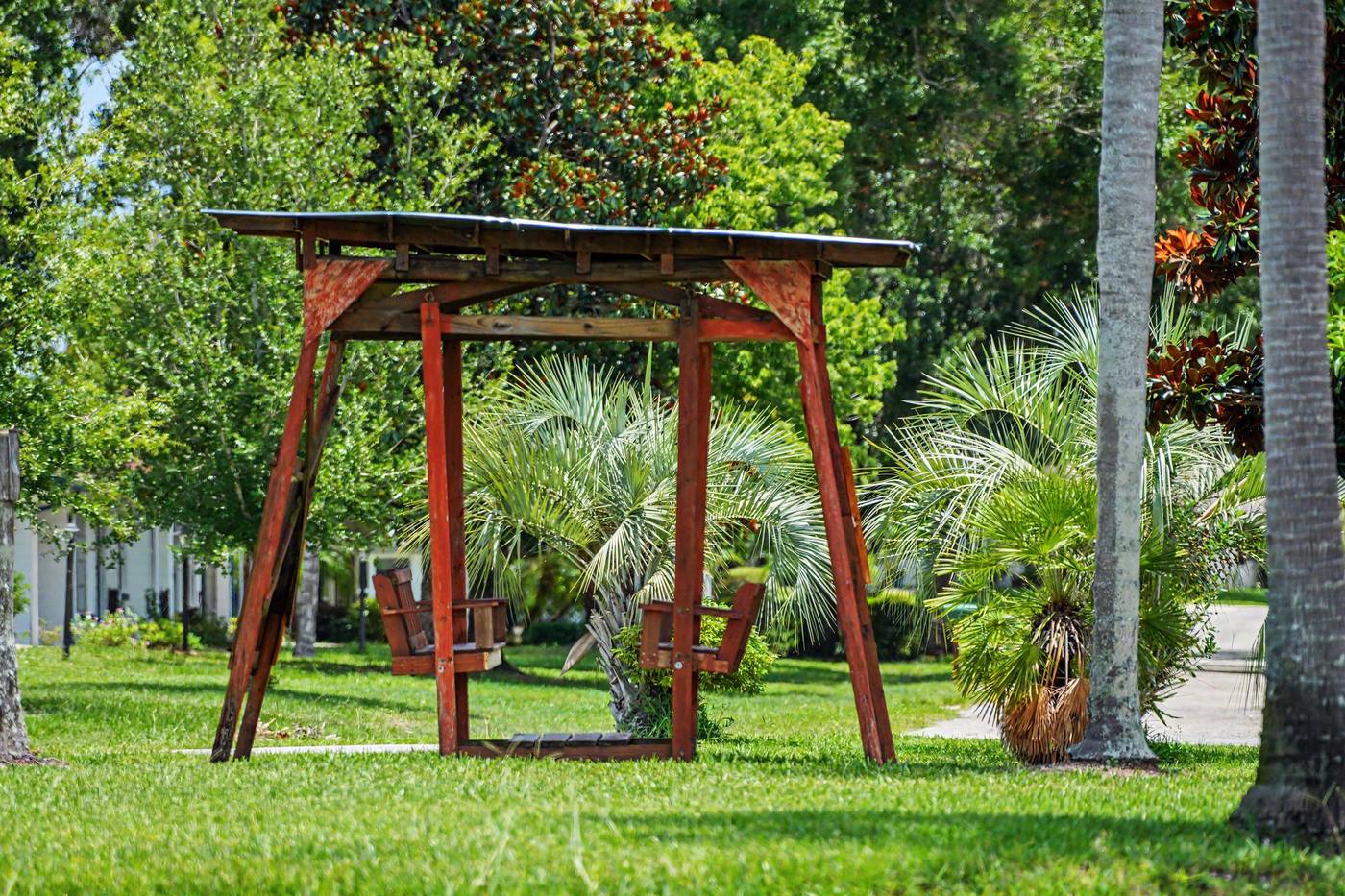 A wooden swing under an arbor on the lawn
